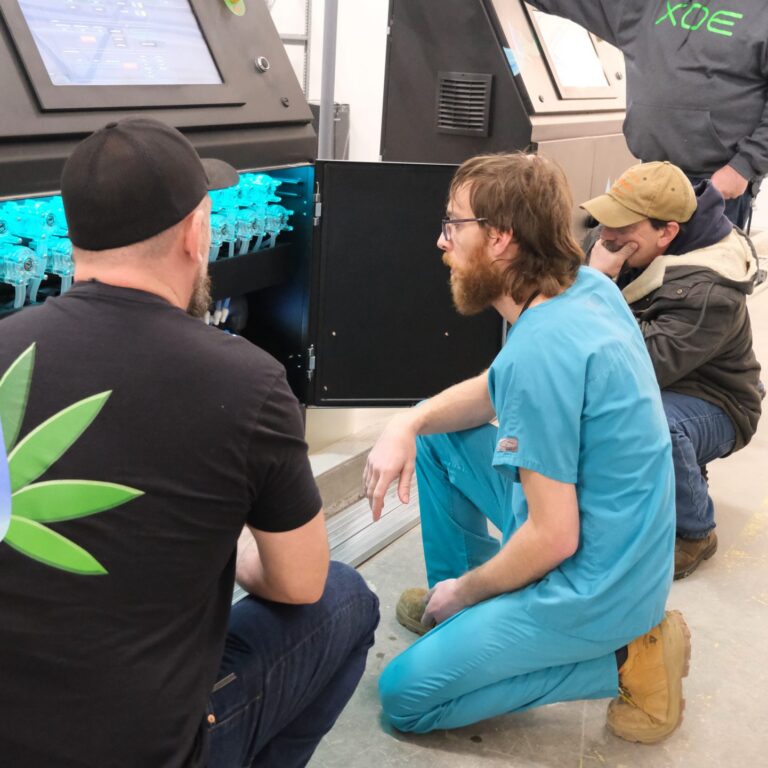 Team inspecting internal dosing components of the Paragon machine