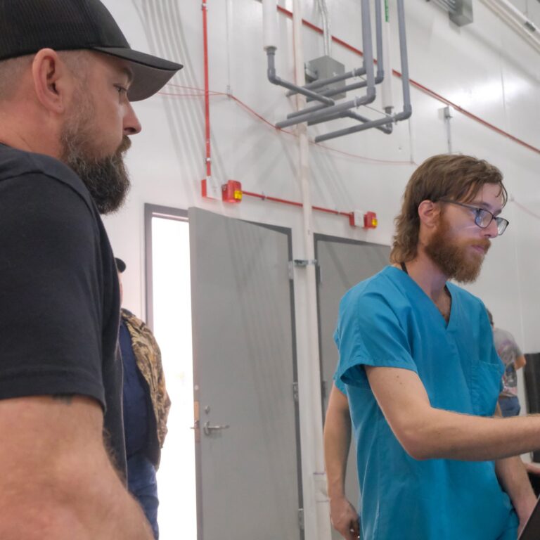 Two men conversing inside a cannabis cultivation facility